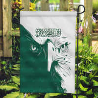 Green and white Saudi falcon garden flag on a stand with Arabic calligraphy