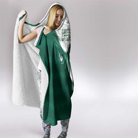 Green and white hooded blanket with hood, falcon face motif, and Arabic text