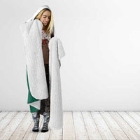 White sherpa-style hooded blanket with green trim and falcon graphic