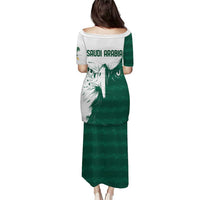 Green long dress, white back panel with “SAUDI ARABIA” text and falcon graphic
