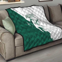 Green and white quilt with diamond stitch pattern and falcon graphic on a sofa