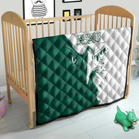 Green and white diamond-stitched quilt with falcon motif on a crib