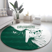 Green round rug featuring white falcon face and Arabic calligraphy design