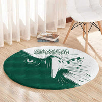 Green round rug with centered white falcon graphic and Arabic calligraphy