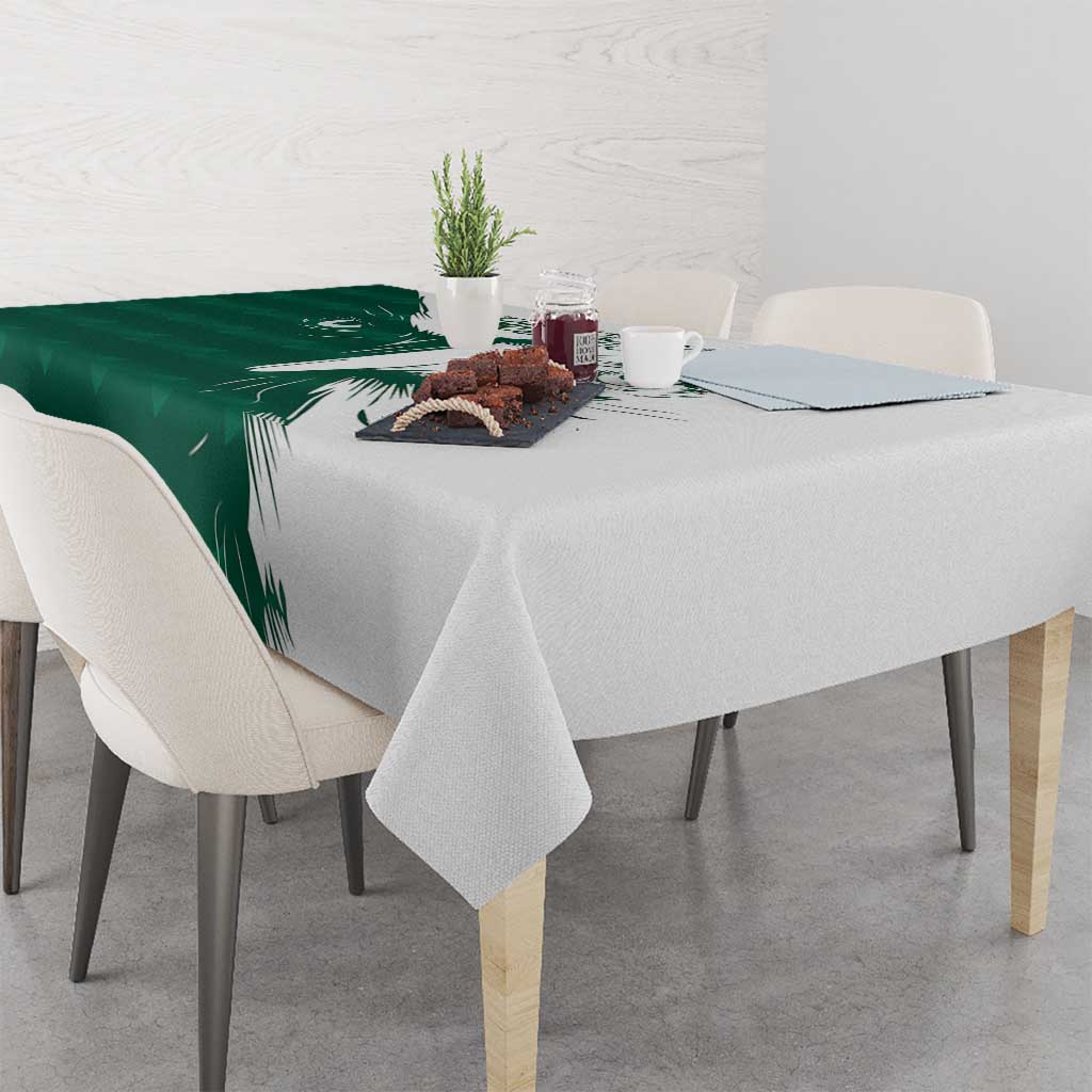 Green and white falcon patterned tablecloth with leaf design, draped on dining table