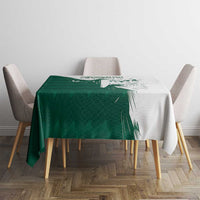 Green and white rectangular tablecloth with falcon graphic and Arabic text on table