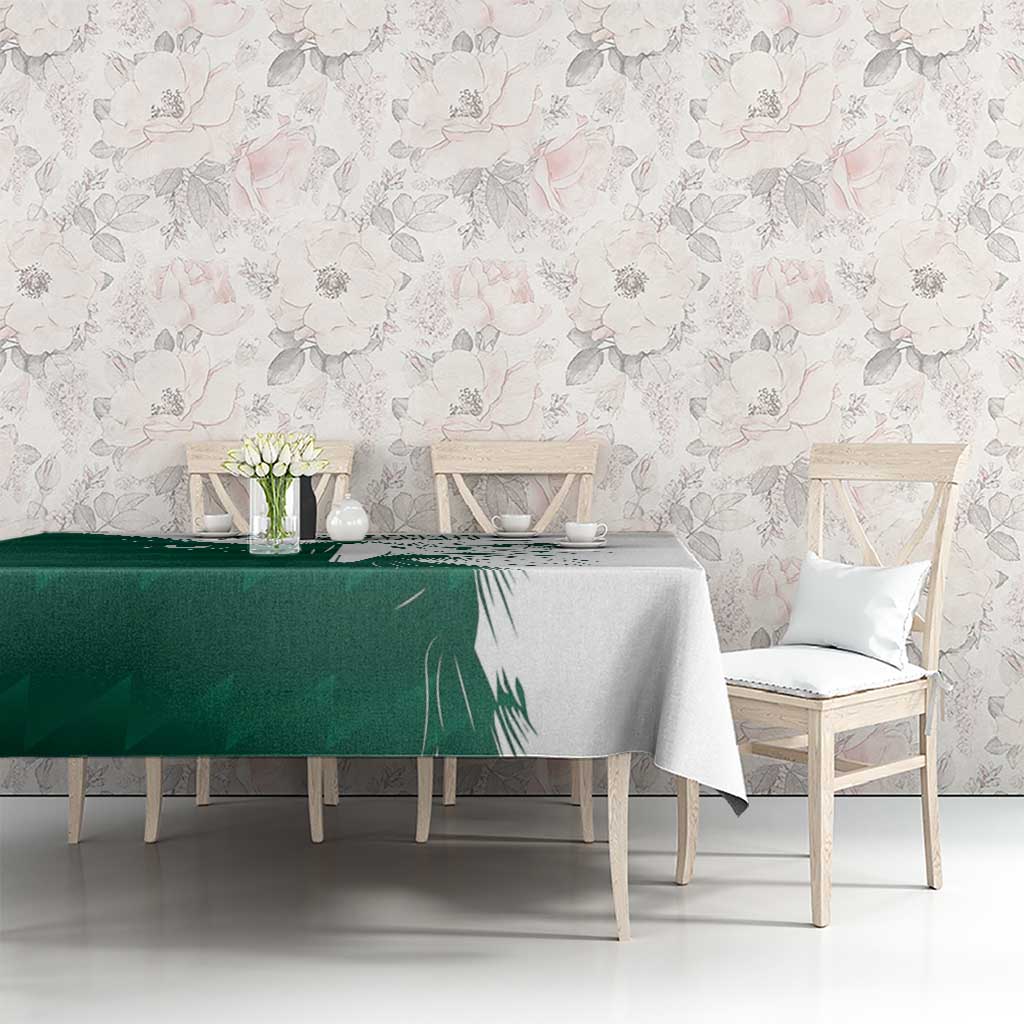 Green and white falcon graphic tablecloth with Arabic-style text, on dining table