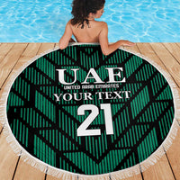 Green circular UAE 21 beach towel blanket with white fringe trim and bold center emblem