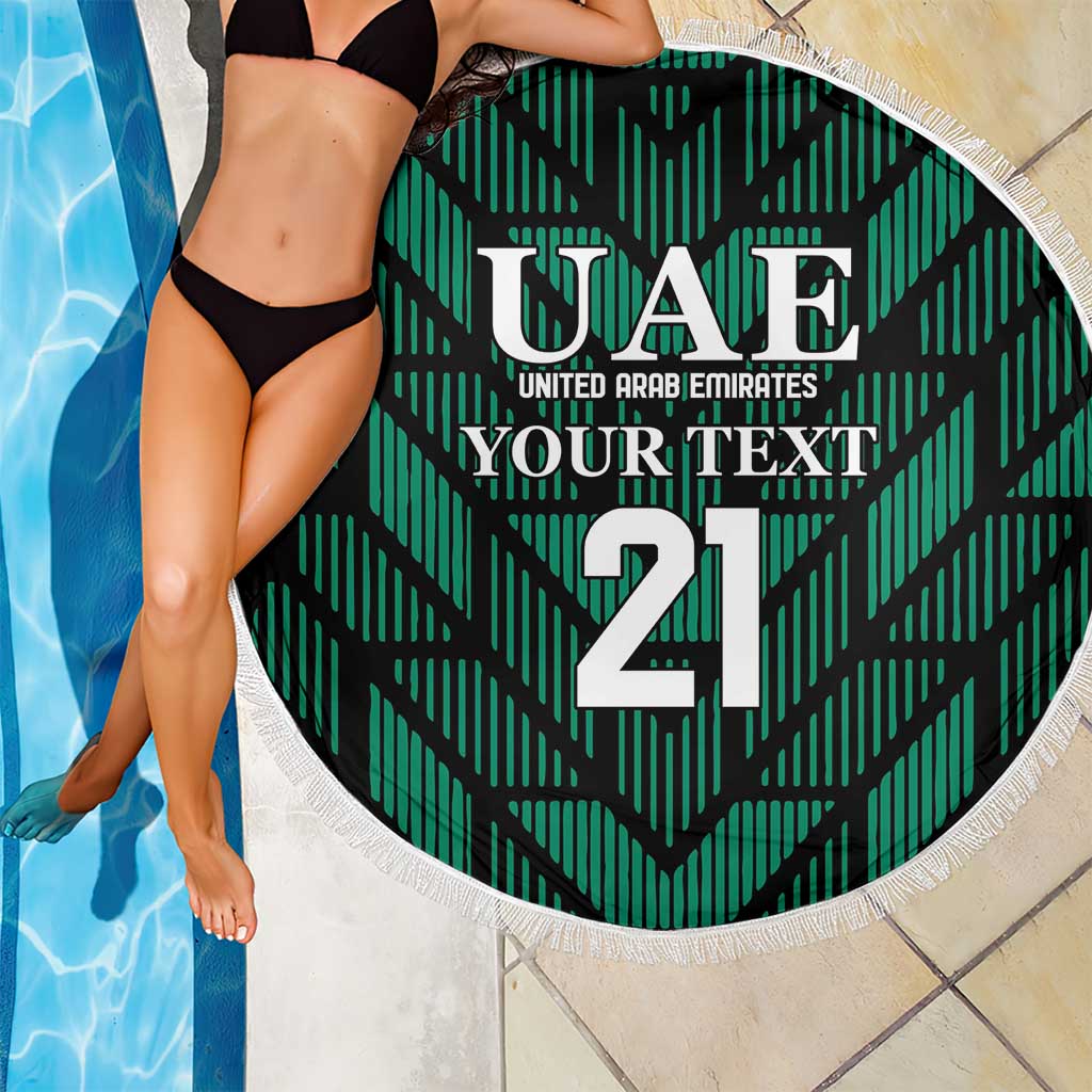 Green circular beach blanket with UAE text and 21 number, white fringe edge beside pool
