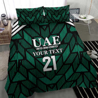 Green comforter with UAE 21 crest and geometric stripe design, with two matching pillows