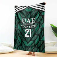 Green football-themed blanket with UAE crest, 'YOUR TEXT', and number 21—draped
