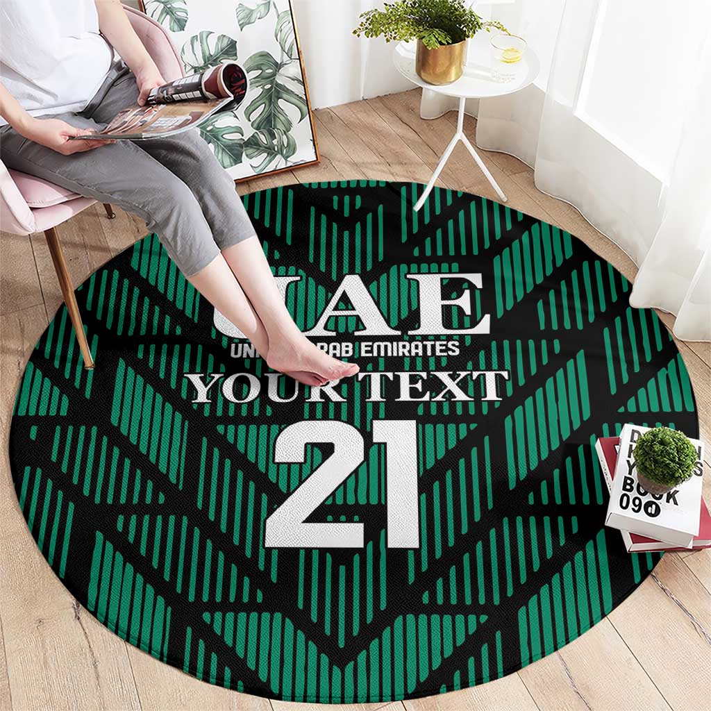Round green football carpet with UAE crest and large 21, shown being placed