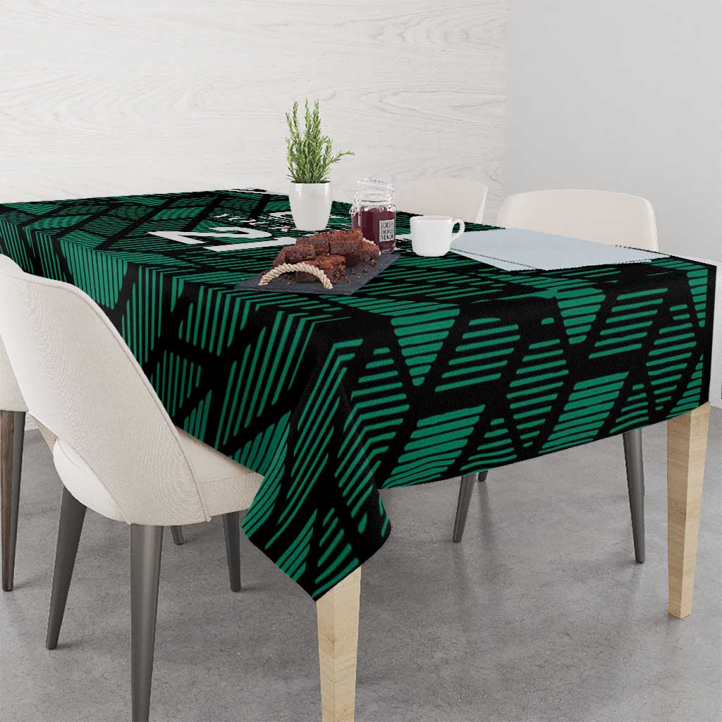 Green football tablecloth with UAE '21' print draped over dining table
