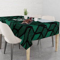 Green football tablecloth with UAE '21' print draped over dining table