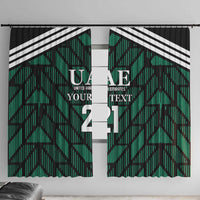 Green window curtain panels with black geometric pattern and UAE text, number print.