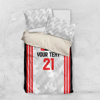 Football bedding set laid flat: black duvet with red striped jersey panel and number 21, 2 pillows