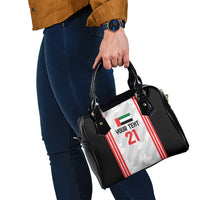 Black shoulder handbag with side view, jersey-style graphic panel and carry handles