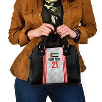 Black handbag with jersey-style front panel graphic, handles, and front zipper area