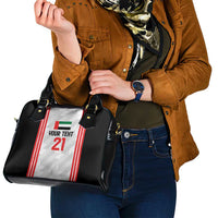 Black handbag worn on shoulder with jersey-style front panel graphic and handles