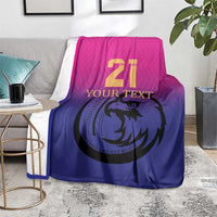 Cricket blanket on gray chair, pink top and blue bottom with 21 falcon emblem