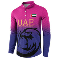 Pink and dark blue button-front cricket sweatshirt with UAE logo and falcon artwork, long sleeves