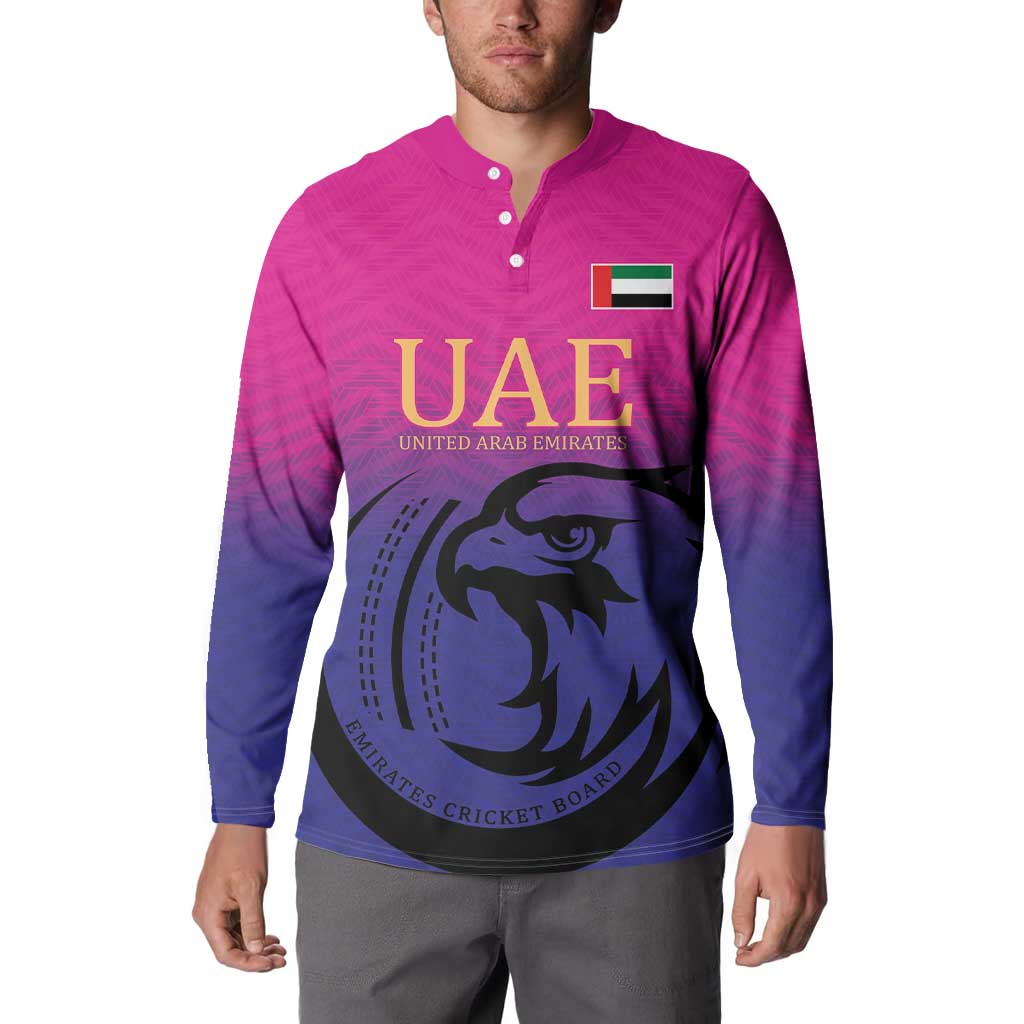 Pink and dark blue button-front cricket sweatshirt with UAE logo and falcon graphic, long sleeves