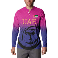 Pink and dark blue button-front cricket sweatshirt with UAE logo and falcon graphic, long sleeves