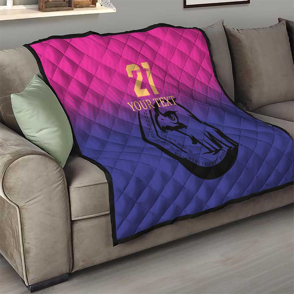 Custom cricket quilt on sofa, pink-to-blue quilted design with number 21 and falcon emblem