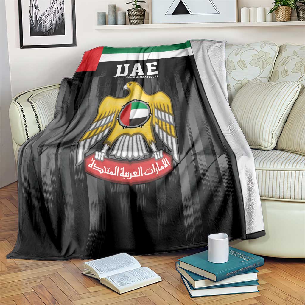 UAE emblem hawk blanket, black with UAE logo and flag colors, draped on sofa