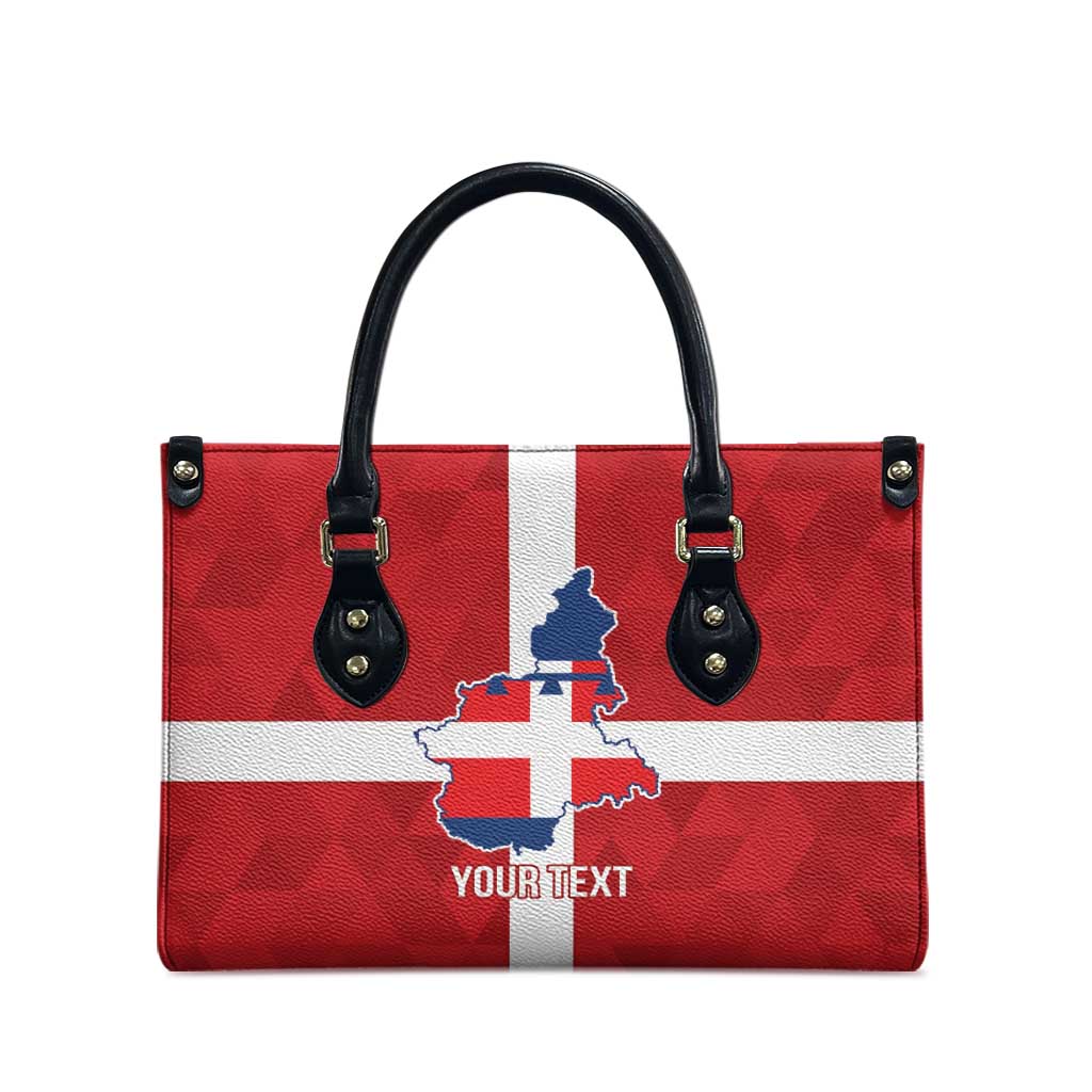 Red leather tote bag with red-and-white flag print, blue crest, and black top handles