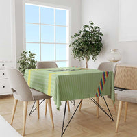 Green tablecloth with multicolor Wiphala-style edge stripes and yellow accent panels