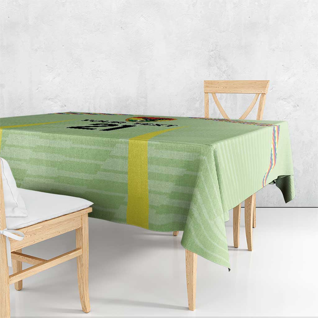 Green tablecloth with Wiphala-style multicolor panel and yellow vertical stripe along edge