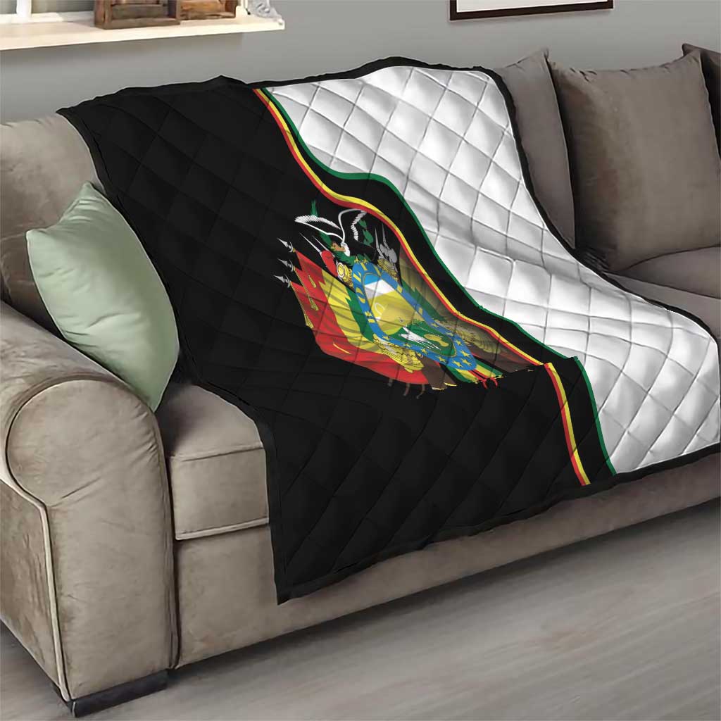 Folded quilt on sofa showing black-and-white panels and Bolivia coat of arms on center.