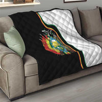 Folded quilt on sofa showing black-and-white panels and Bolivia coat of arms on center.