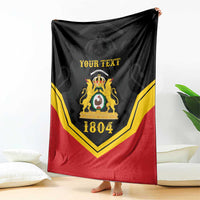 Black/red/yellow personalized throw blanket with crest and “YOUR TEXT”, 1804, draped
