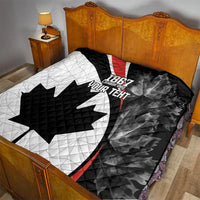 Black and white quilt with red stripe and quilted maple leaf motif over bed