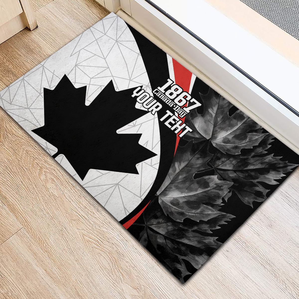 Canada-themed rubber doormat with black maple leaf, gray geometric background, red accent