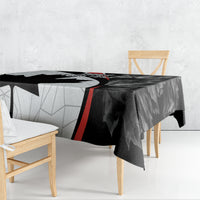 Black graphic Canada Day tablecloth draped over dining table with red stripe