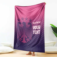 Football-themed blanket draped indoors, pink-to-purple gradient with 'YOUR TEXT' lettering