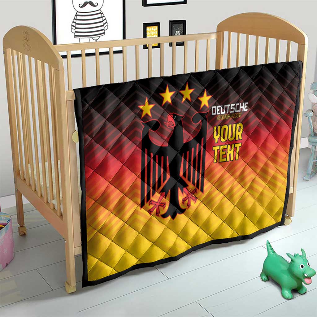 Gradient quilt blanket on a crib with black eagle emblem and “DEUTSCHE YOUR TEXT” design