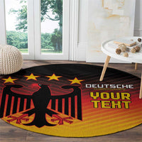 Round black rug featuring red eagle, stars, and 'DEUTSCHE' lettering with yellow gradient