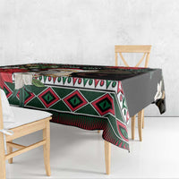 Christmas tablecloth draped over a table, showing black base with red and green geometric trim
