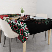 Christmas tablecloth on a dining table, black with green diamond pattern and red accents