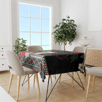 Christmas tablecloth on a dining table with black background, red and green geometric design