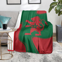 Red and green lion emblem blanket tossed over chair in Moroccan flag colors
