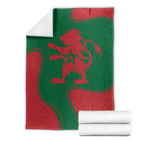 Red and green lion emblem blanket with flag pattern, stacked with white towels