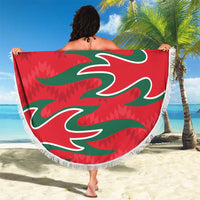 Red round beach blanket with fringed edge, '21 YOUR TEXT' and green Oman emblem held