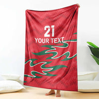 Red cricket blanket with green flame-like design, white “YOUR TEXT” and number 21
