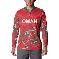 Red Oman cricket button sweatshirt with green flame graphic and OMAN logo, worn by model