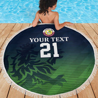 Round beach blanket with fringe edge, green camo pattern and number 21, held over shoulders